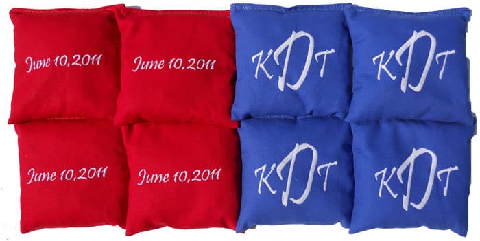 Red and blue wedding cornhole bags embroidered with a monogram and the wedding date