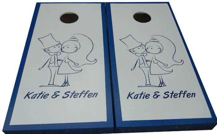 Matching custom wedding cornhole boards with blue trim and a hand-drawn bride and groom