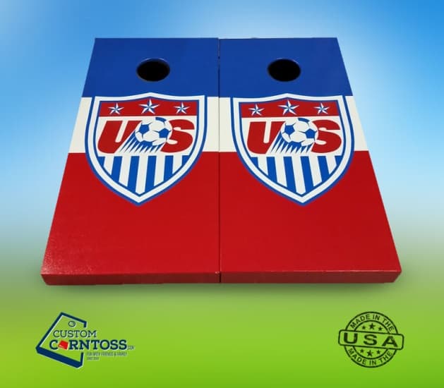 Custom cornhole boards painted red, white, and blue with the U.S. Soccer crest